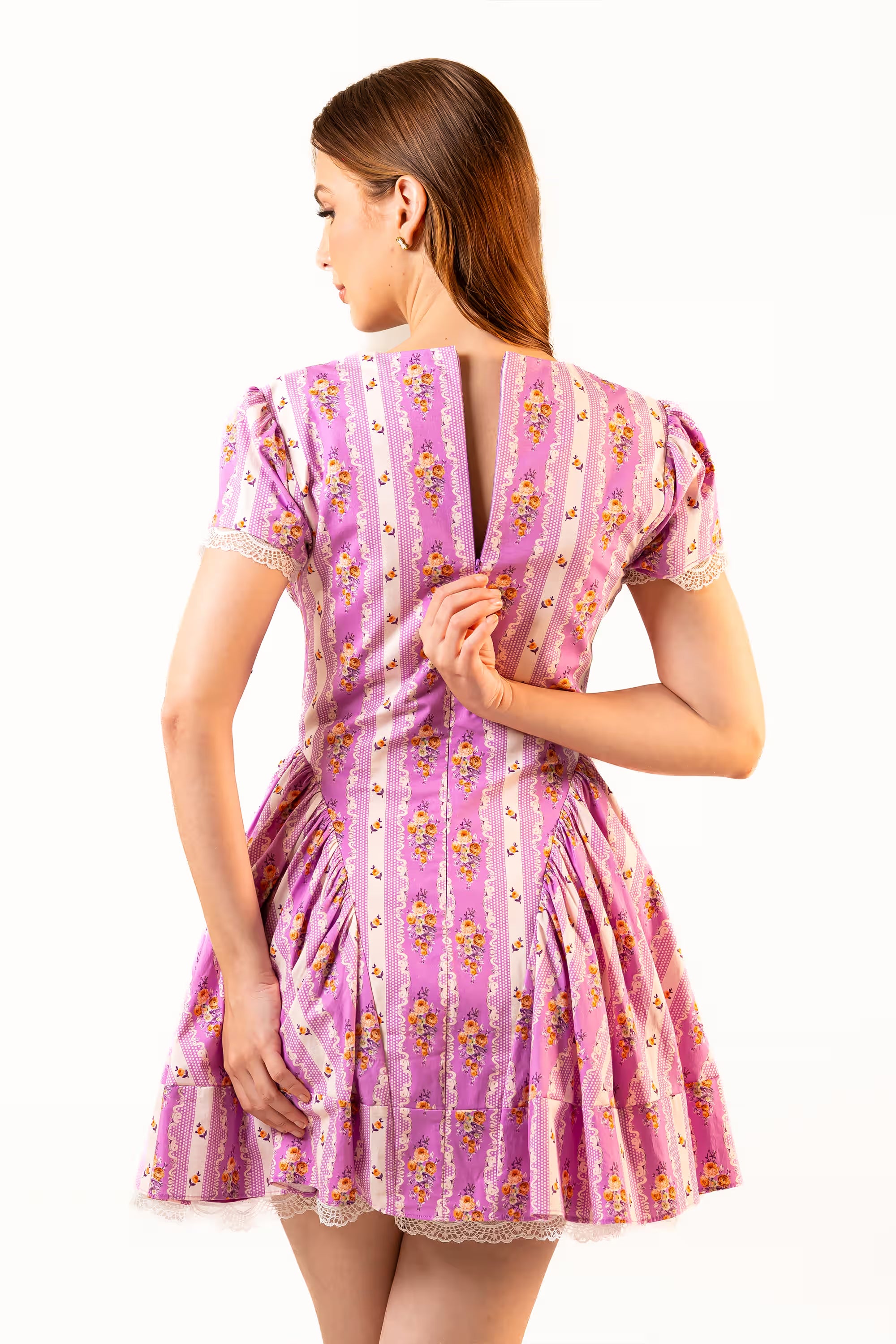Back view of purple floral lace-trim mini dress with open V-back and short sleeves.