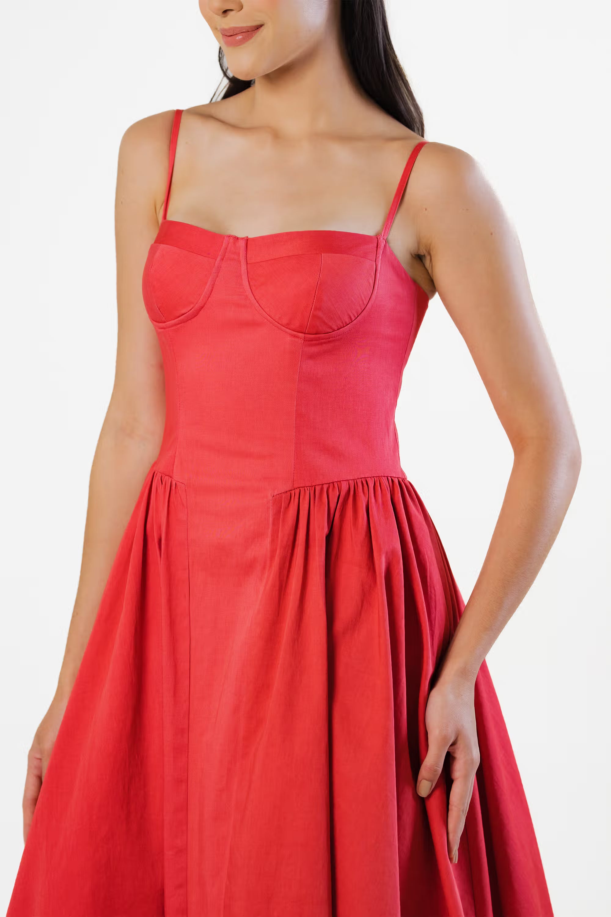 Close-up of red corset dress bodice with structured cups and pleated waist