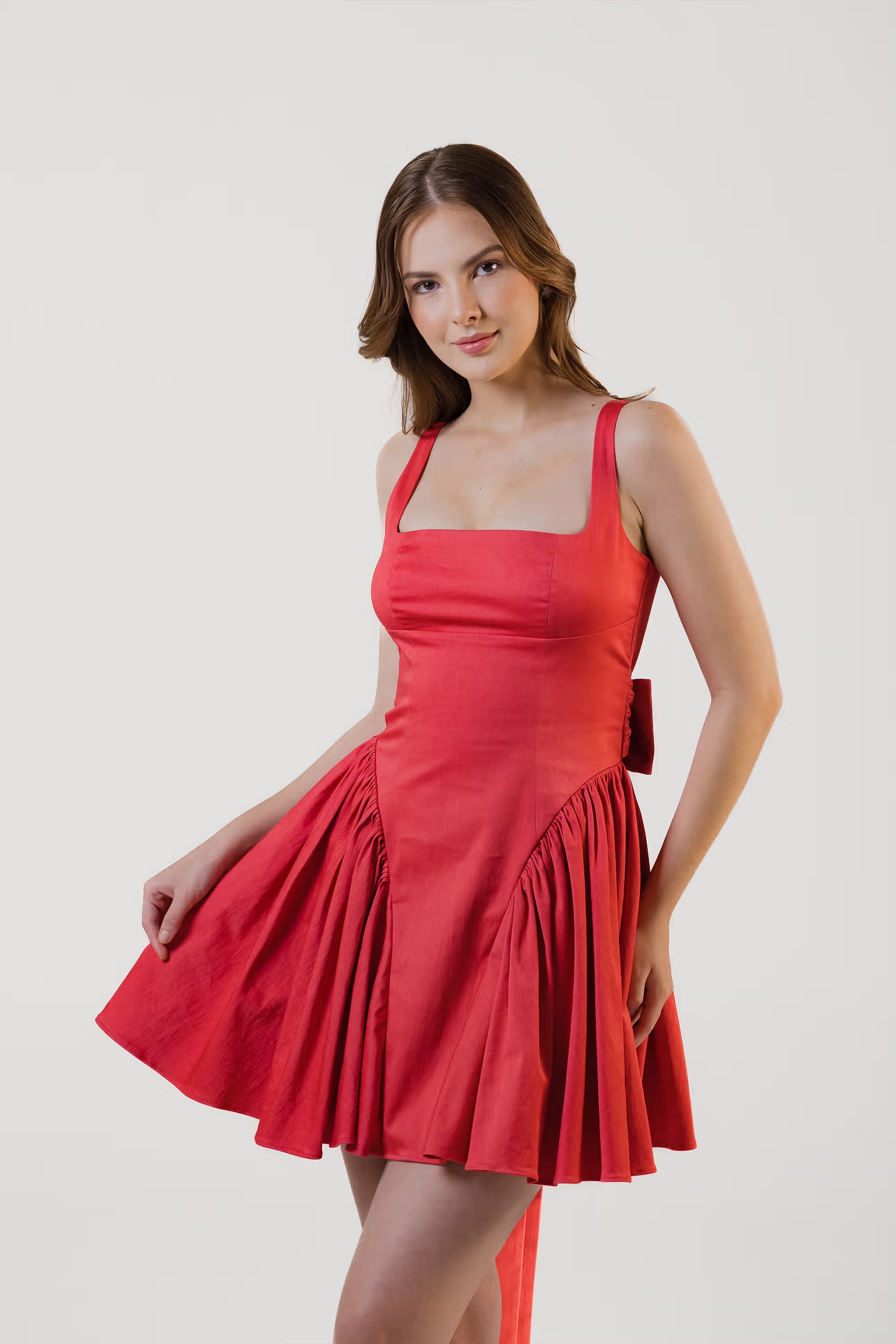 Side view of red sleeveless mini dress with square neckline and flared skirt