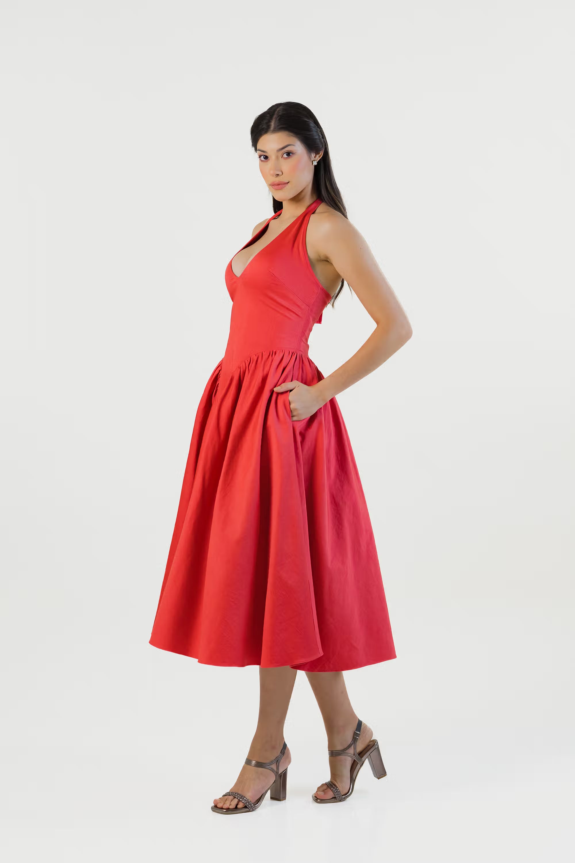 Red halter midi dress with side pockets and fitted waist shown on model