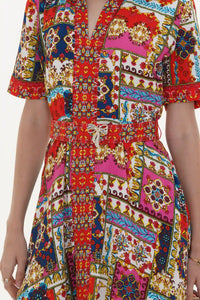 Close-up of Pretty Pixie red and pink patchwork-print belted V-neck dress with crystal bow brooch
