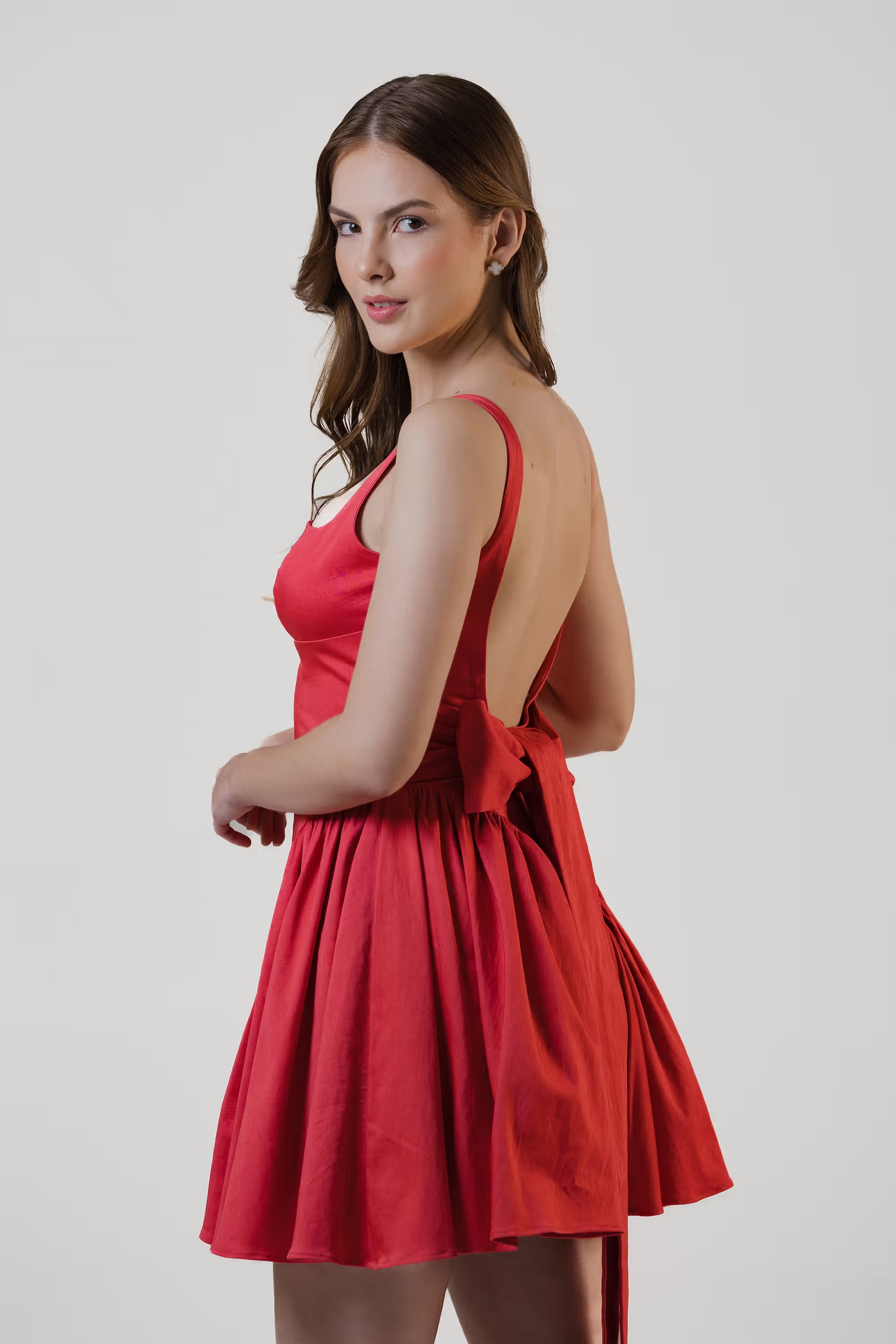 Women in red flared mini dress showing open back and waist bow detail