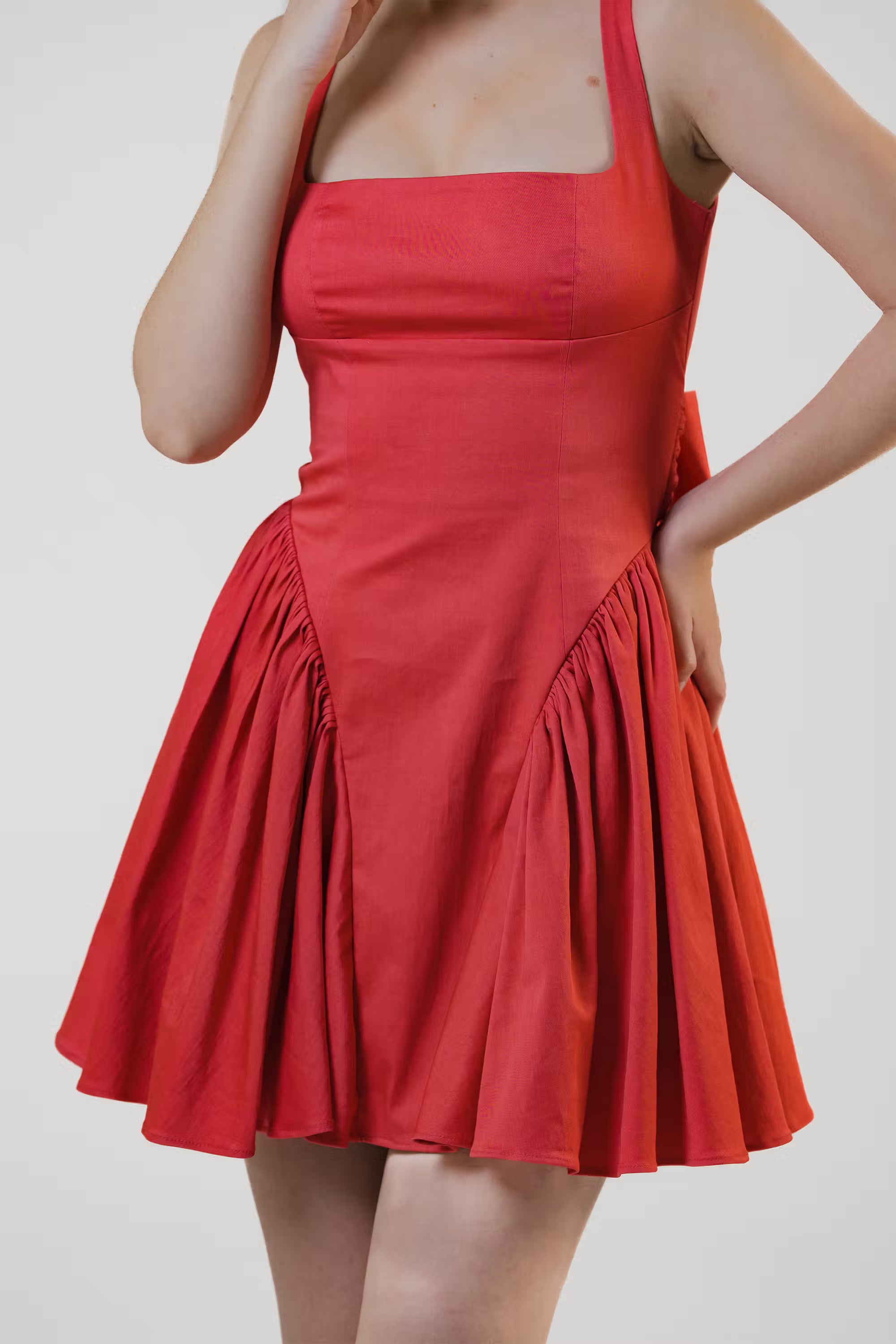 Close-up of red mini dress with square neckline and ruched waist design