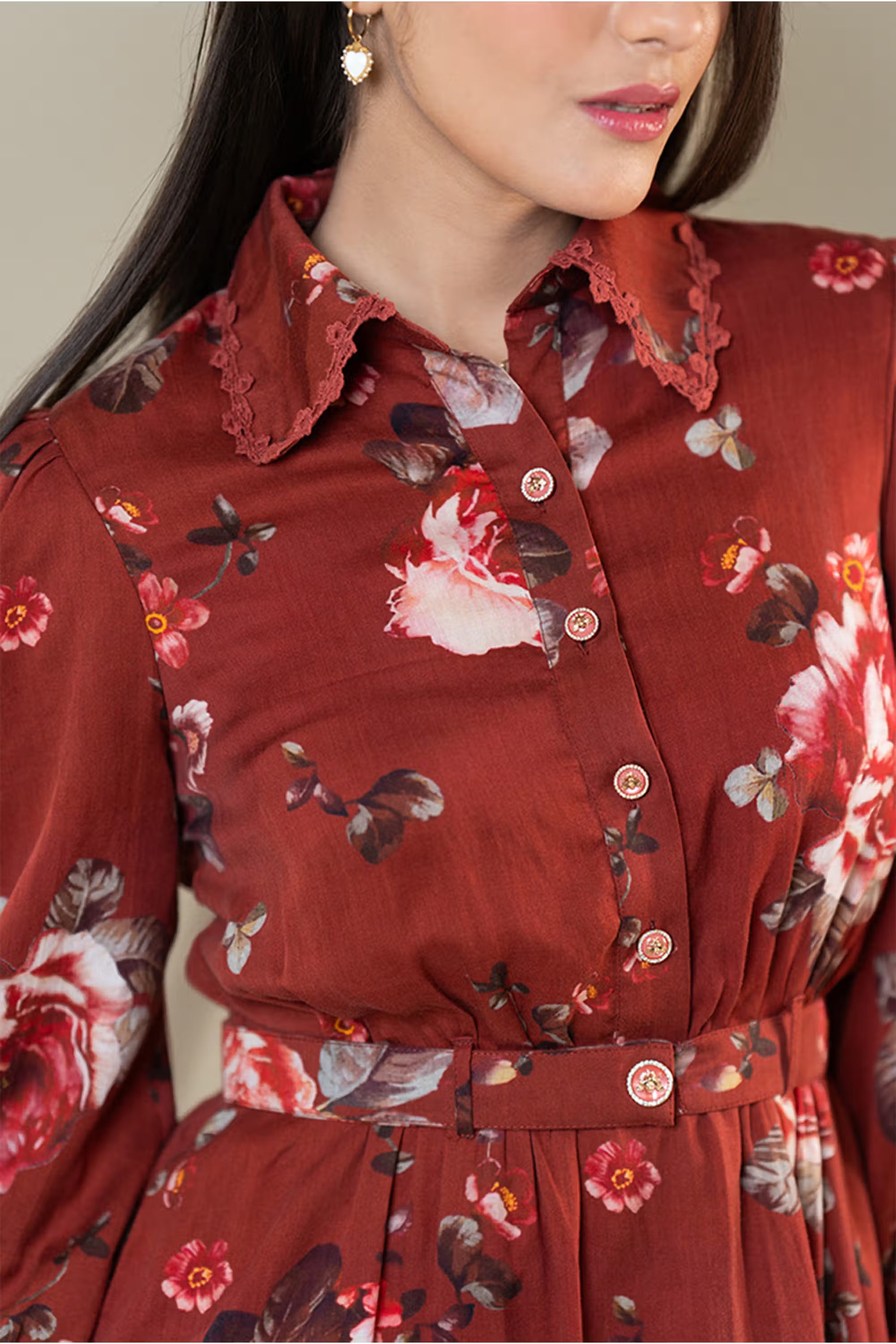 Model posing in rust red floral shirt dress with collared neckline and smocked cuffs