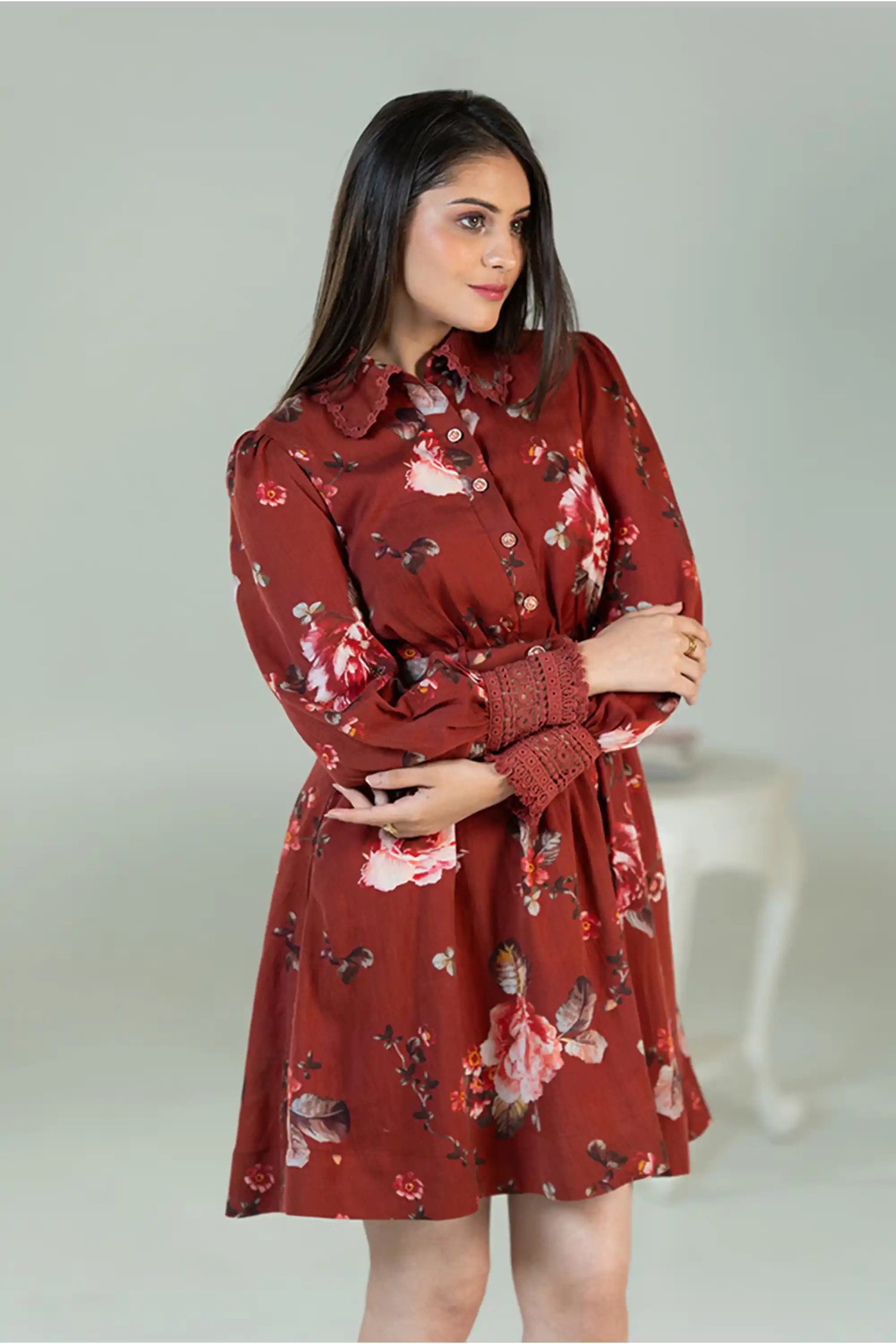 Model posing in rust red floral shirt dress with belt
