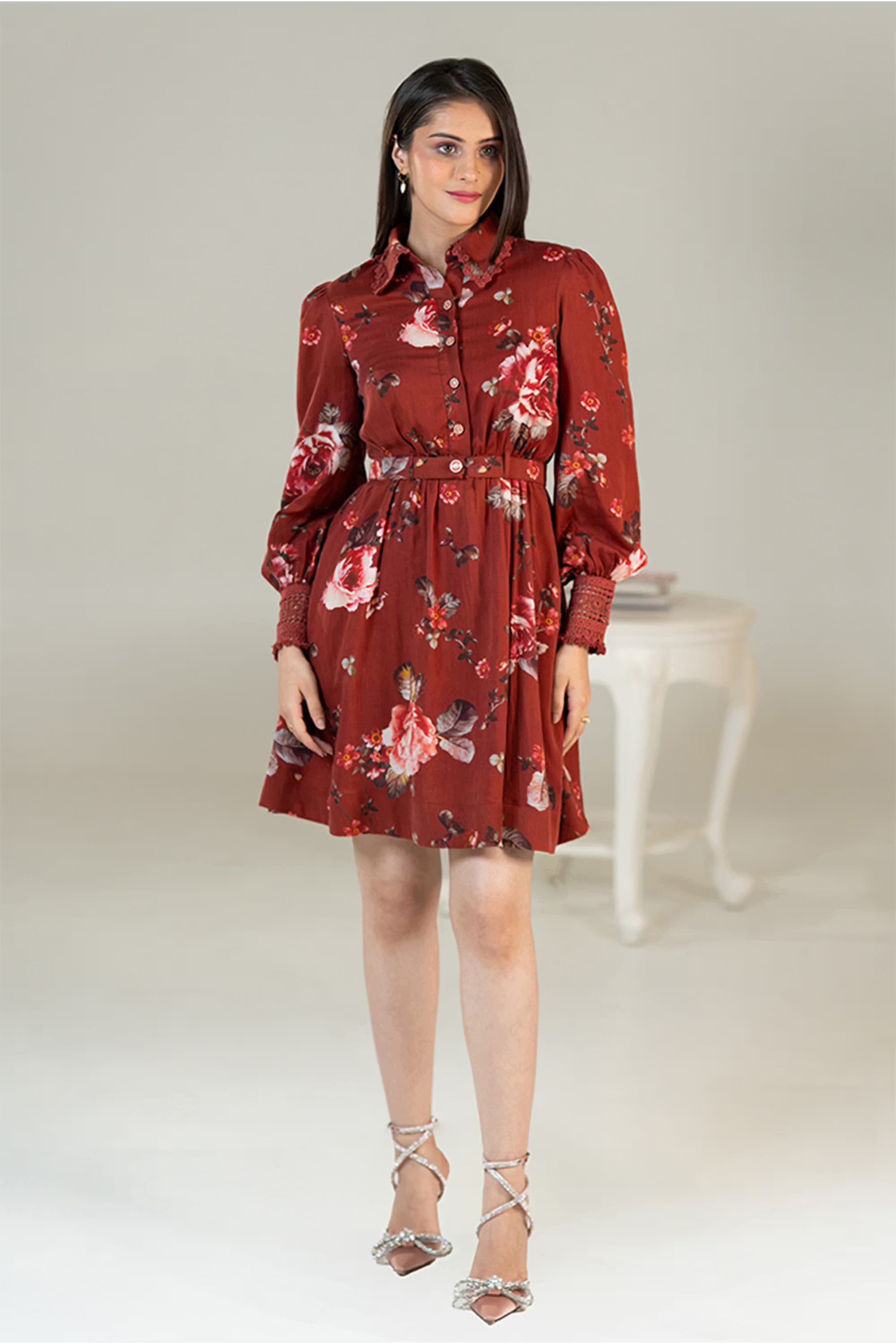 Front view of rust red floral shirt dress with long sleeves, belted waist, and button-down design