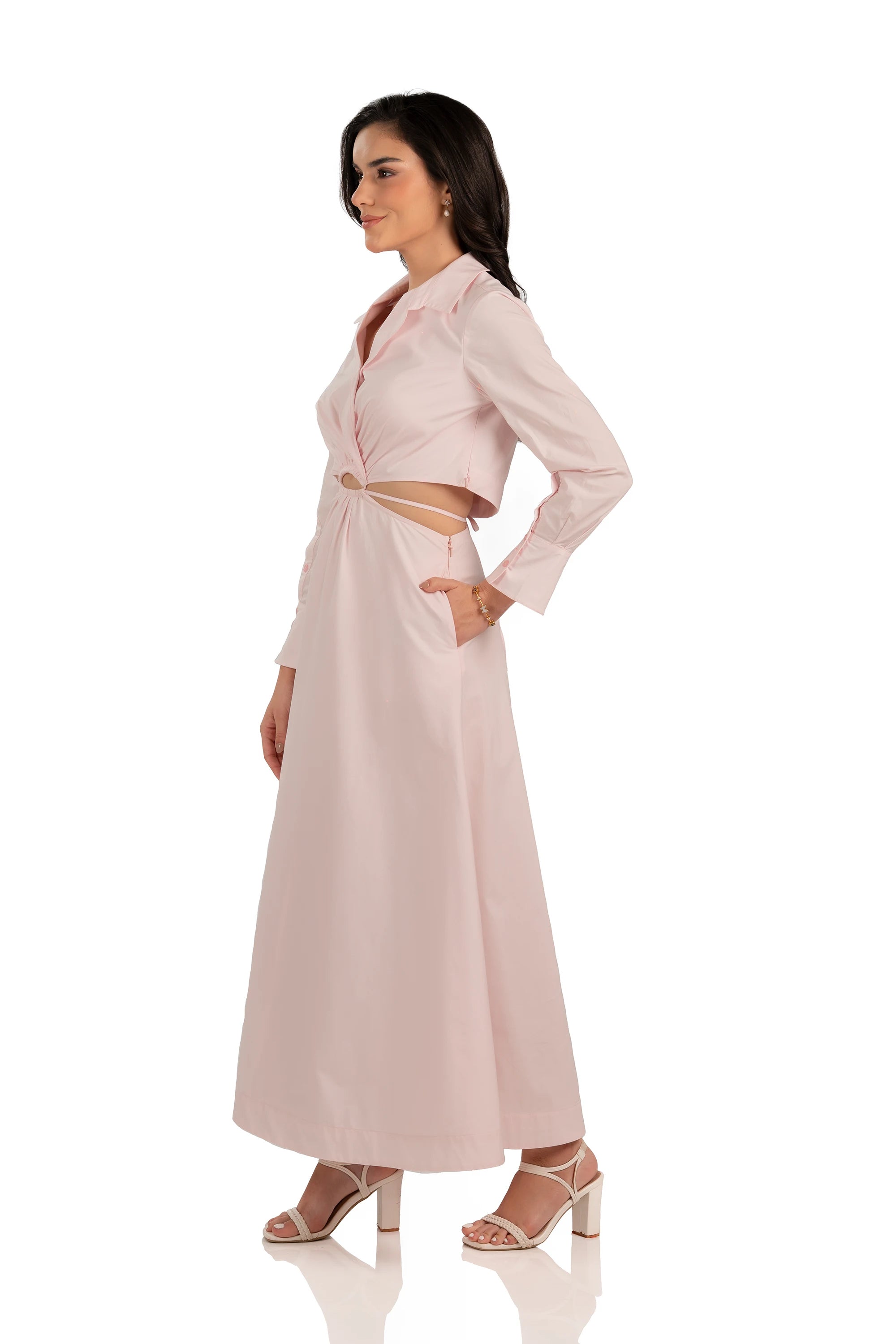 Side profile of blush pink cutout maxi dress with collared neckline, fitted waist, and long sleeves.