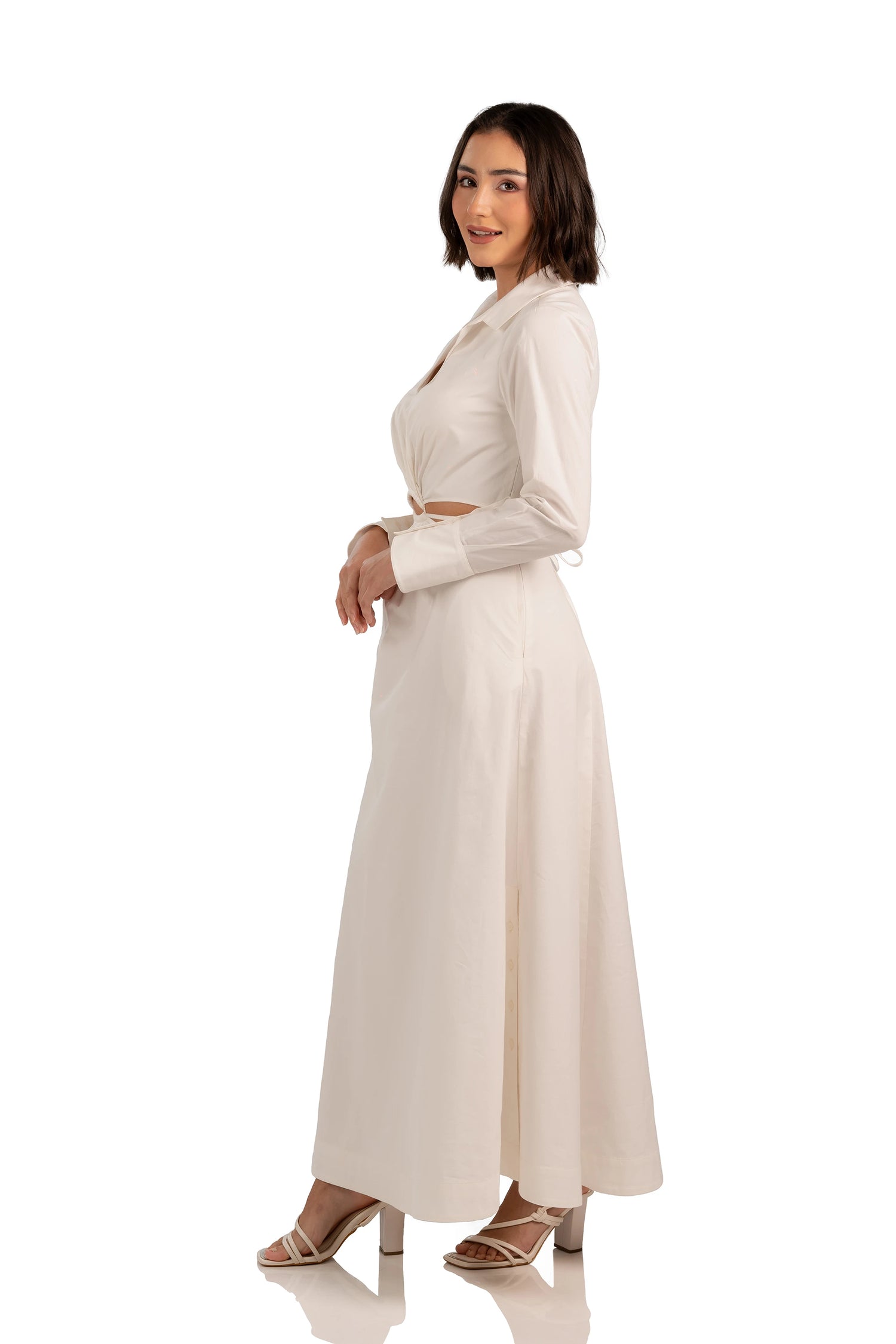 Side profile of cream long sleeve maxi dress featuring cutout waist and collared neckline.