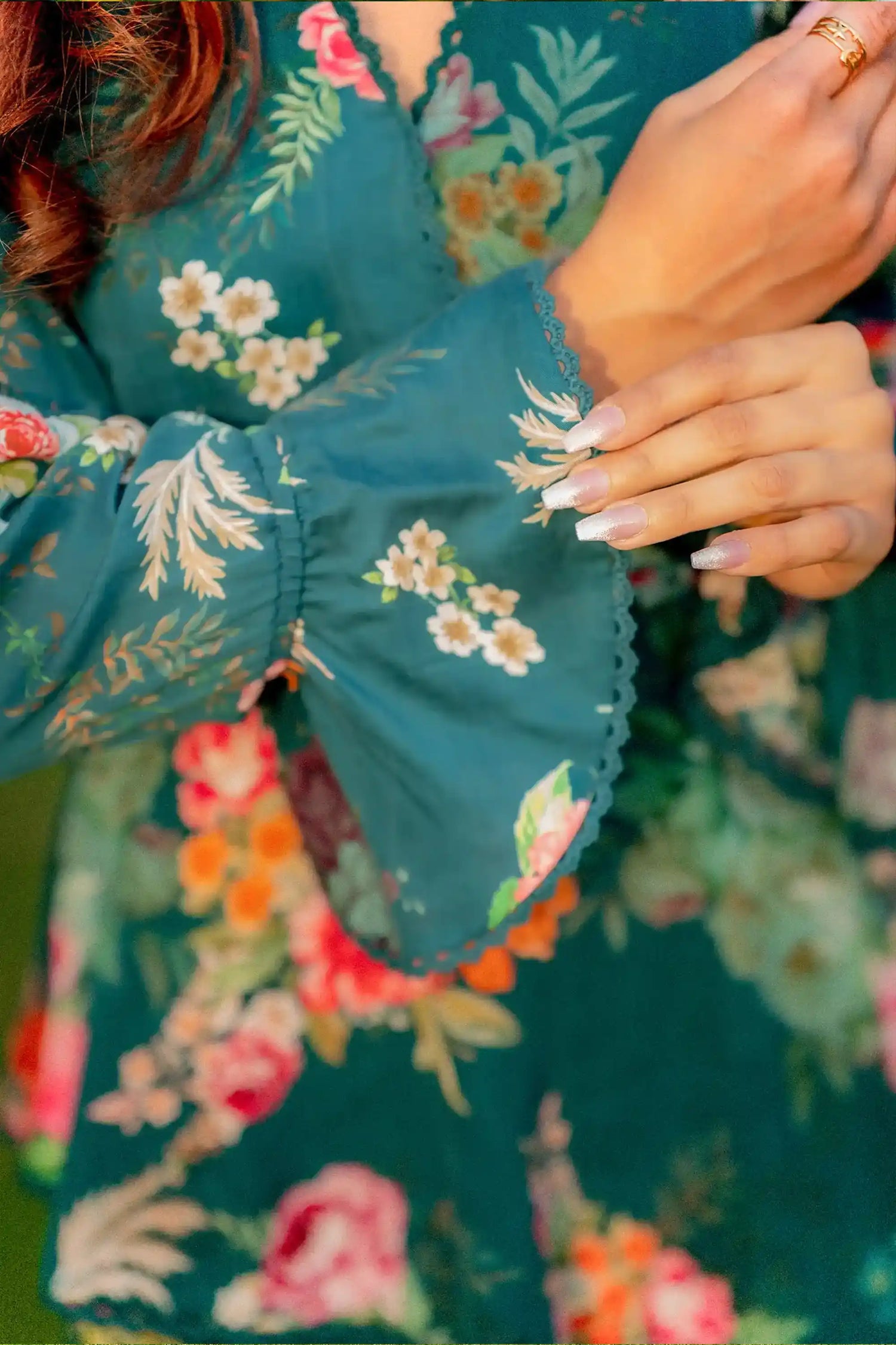 Sleeve detail of teal floral ruffle wrap dress
