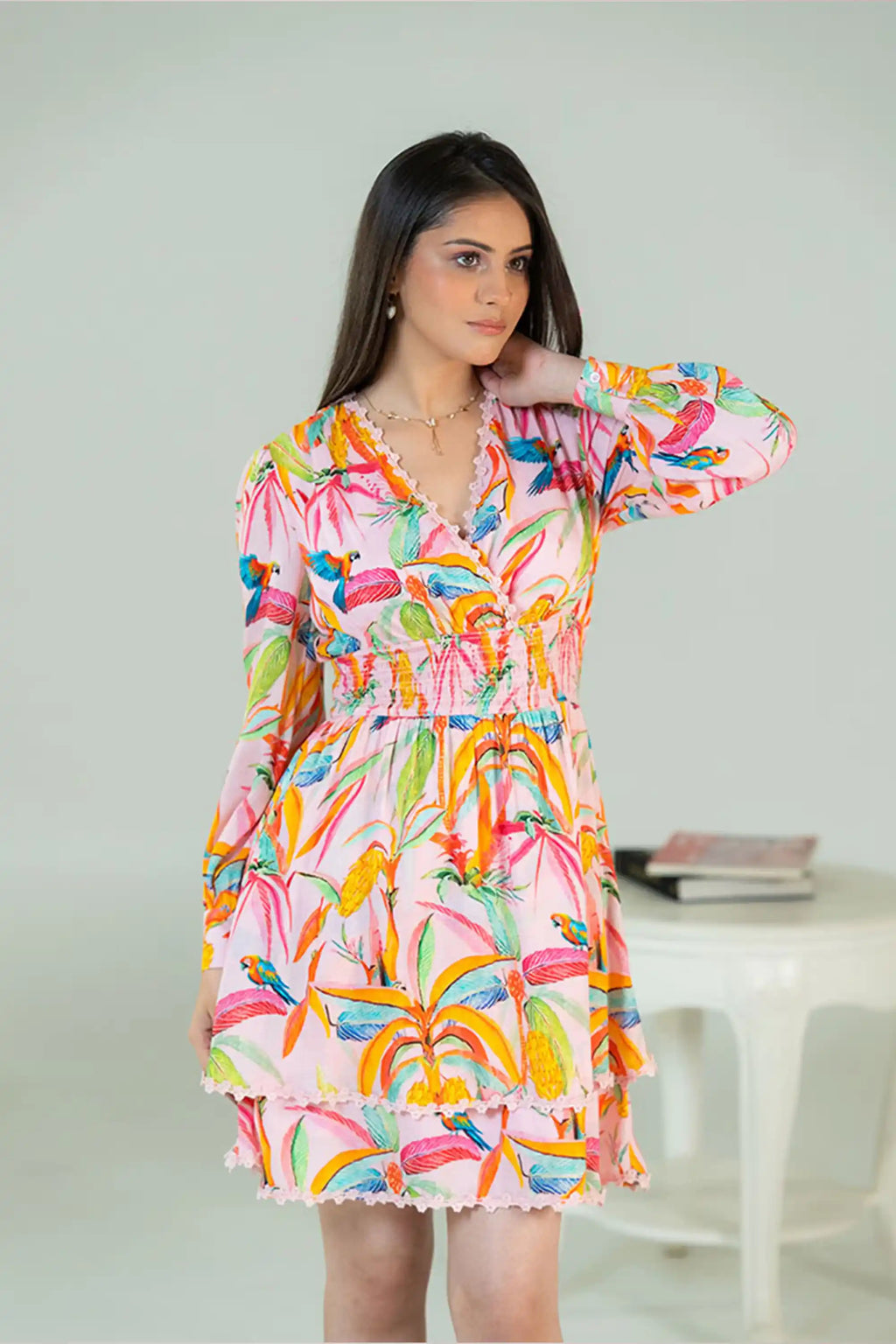 Elegant pose in tropical parrot print pink dress with v-neck design