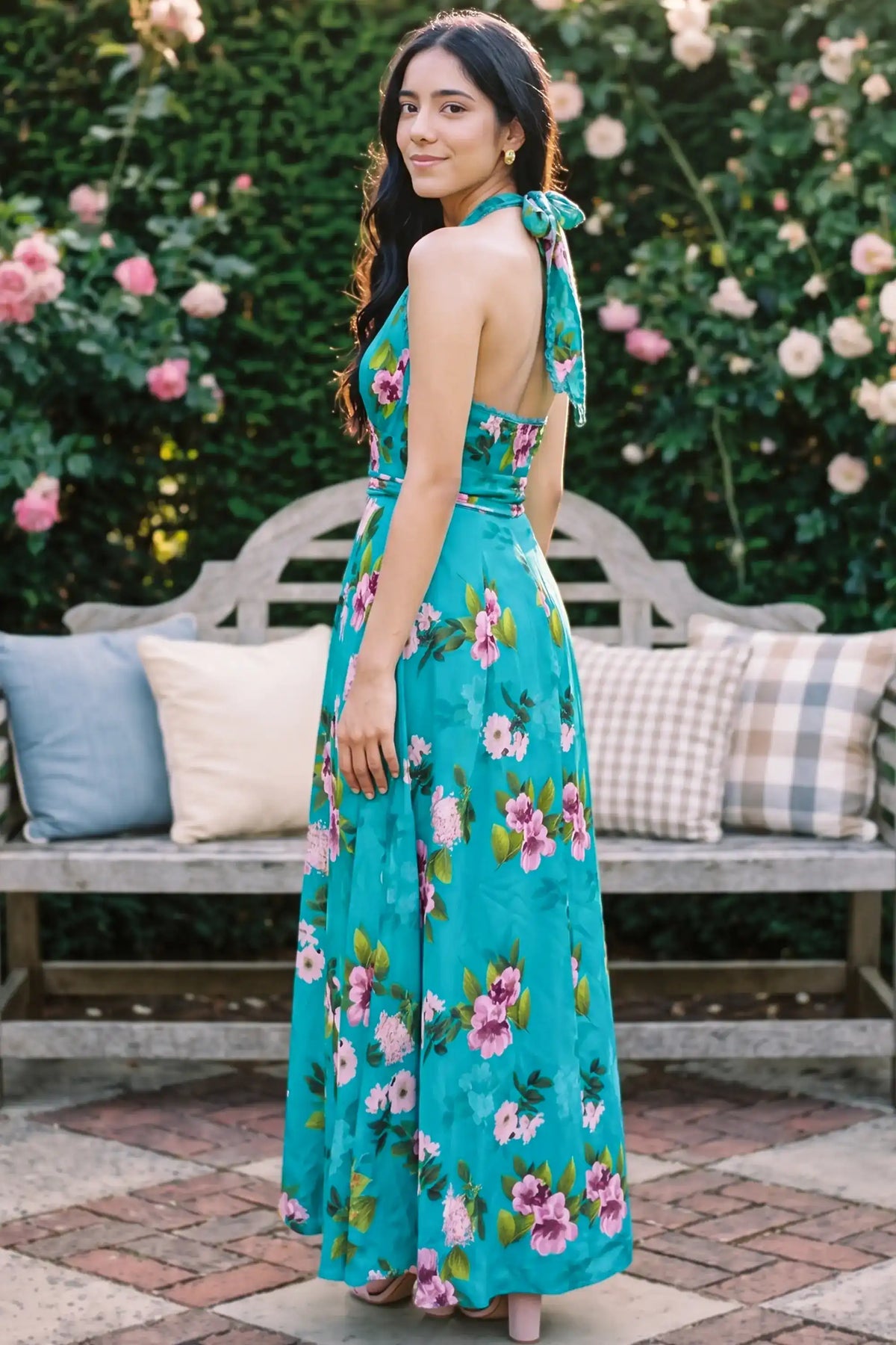 Back view showing turquoise floral halter maxi dress with open back and decorative tie closure; women's occasion dress