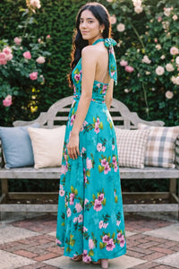 Back view showing turquoise floral halter maxi dress with open back and decorative tie closure; women's occasion dress