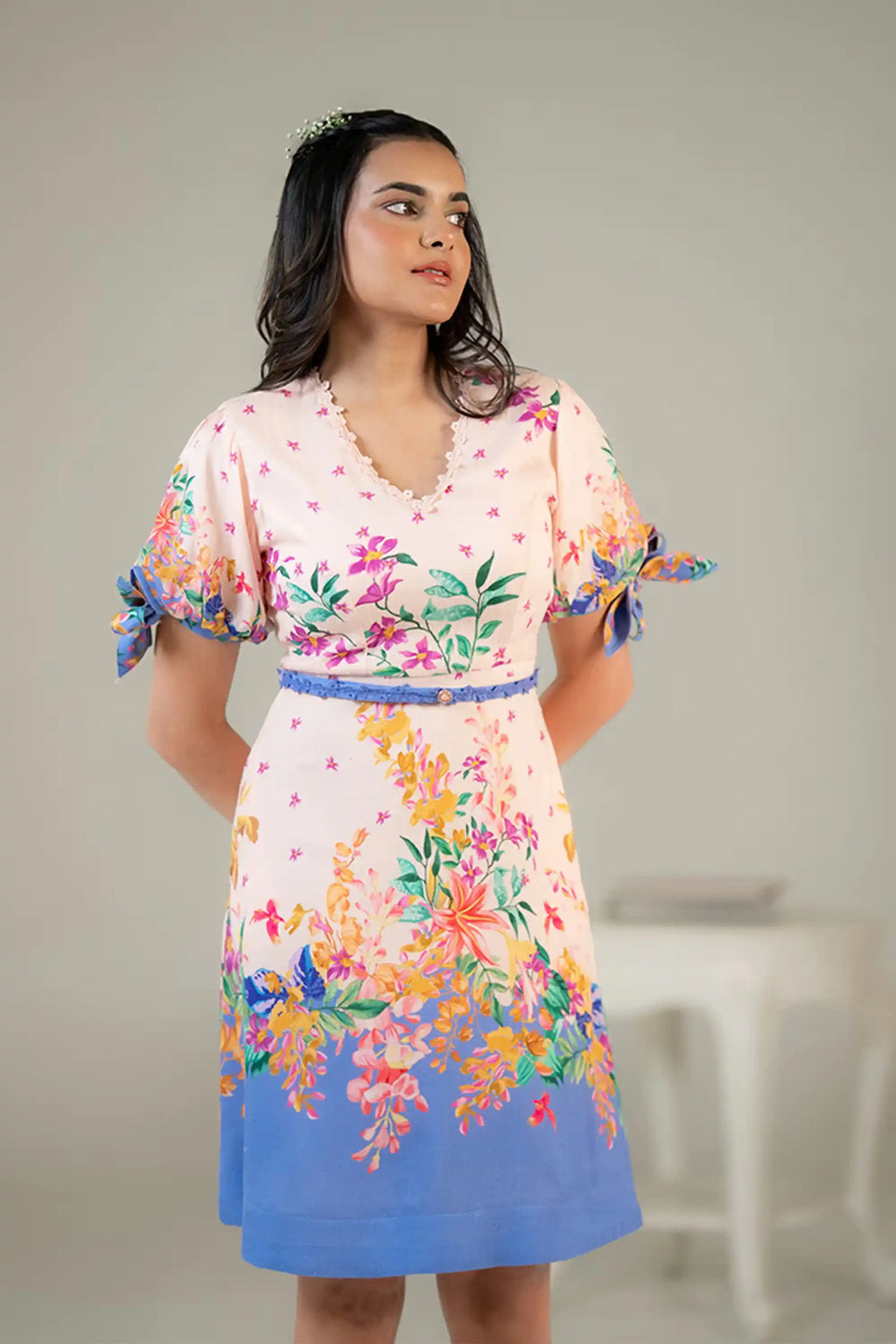 V-neck pink floral dress with blue belt and border hem