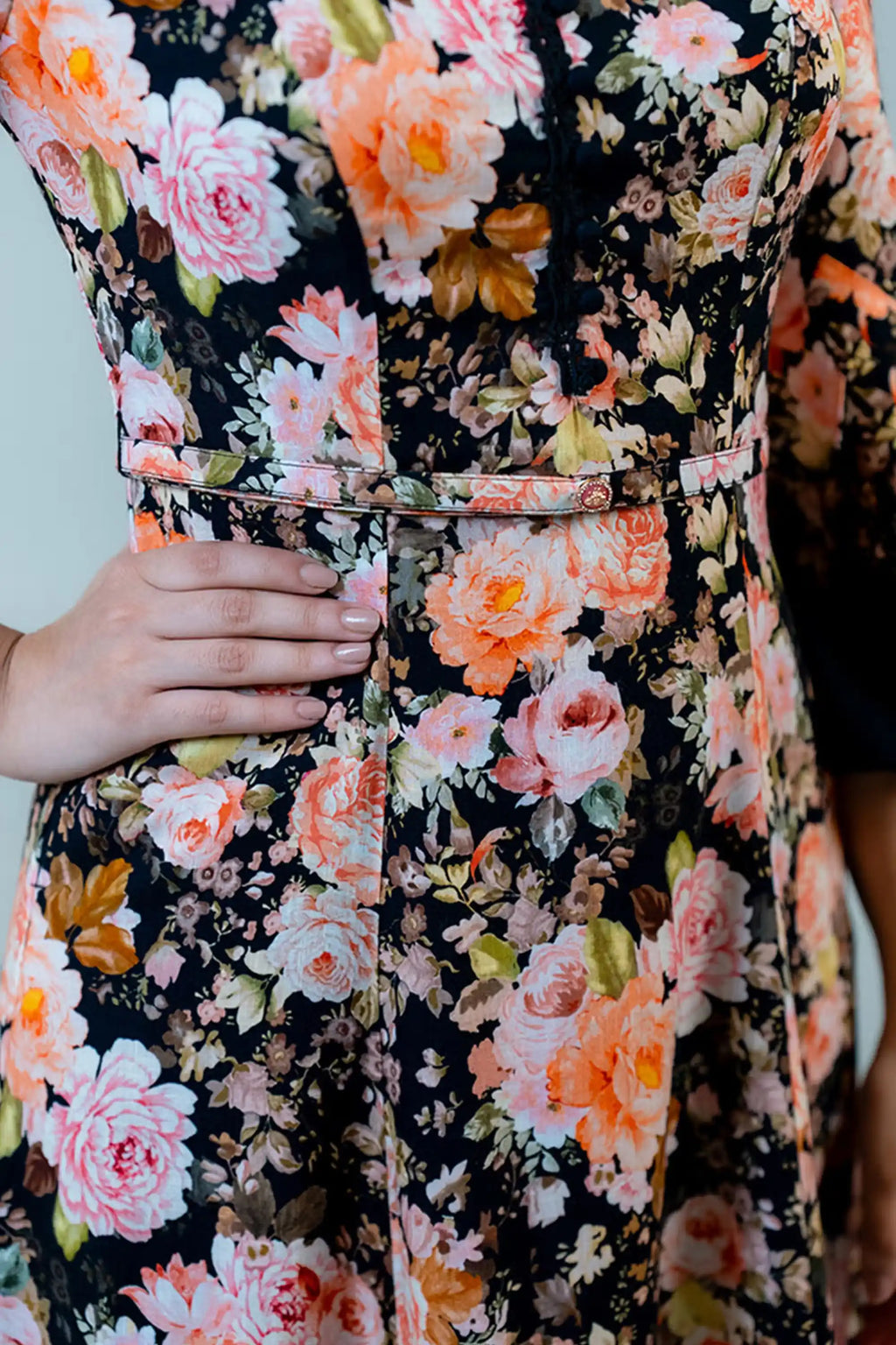 Waist detail of black floral midi dress with belted design