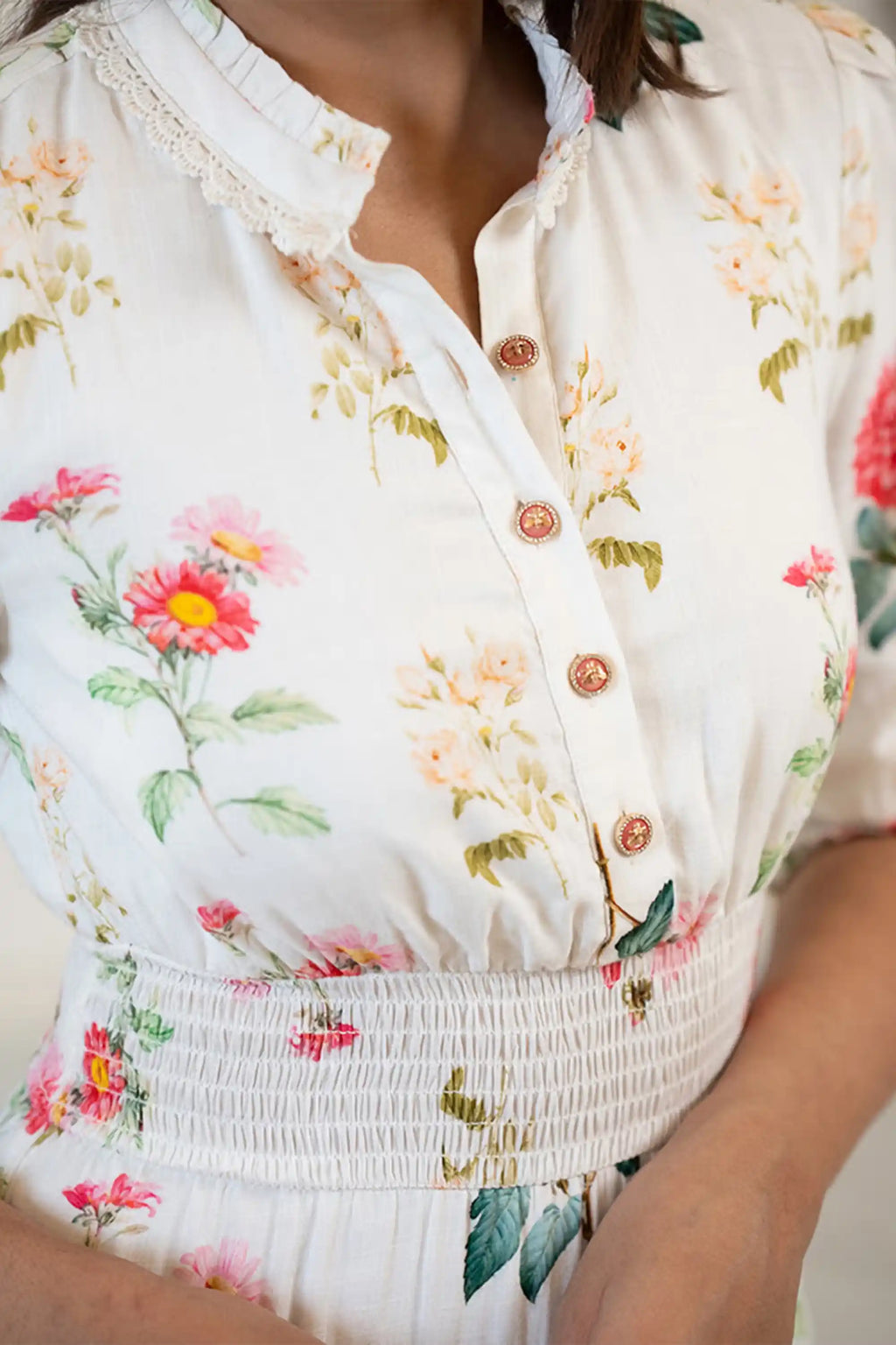 Closeup of buttons and neckline on white floral ruffle mini dress