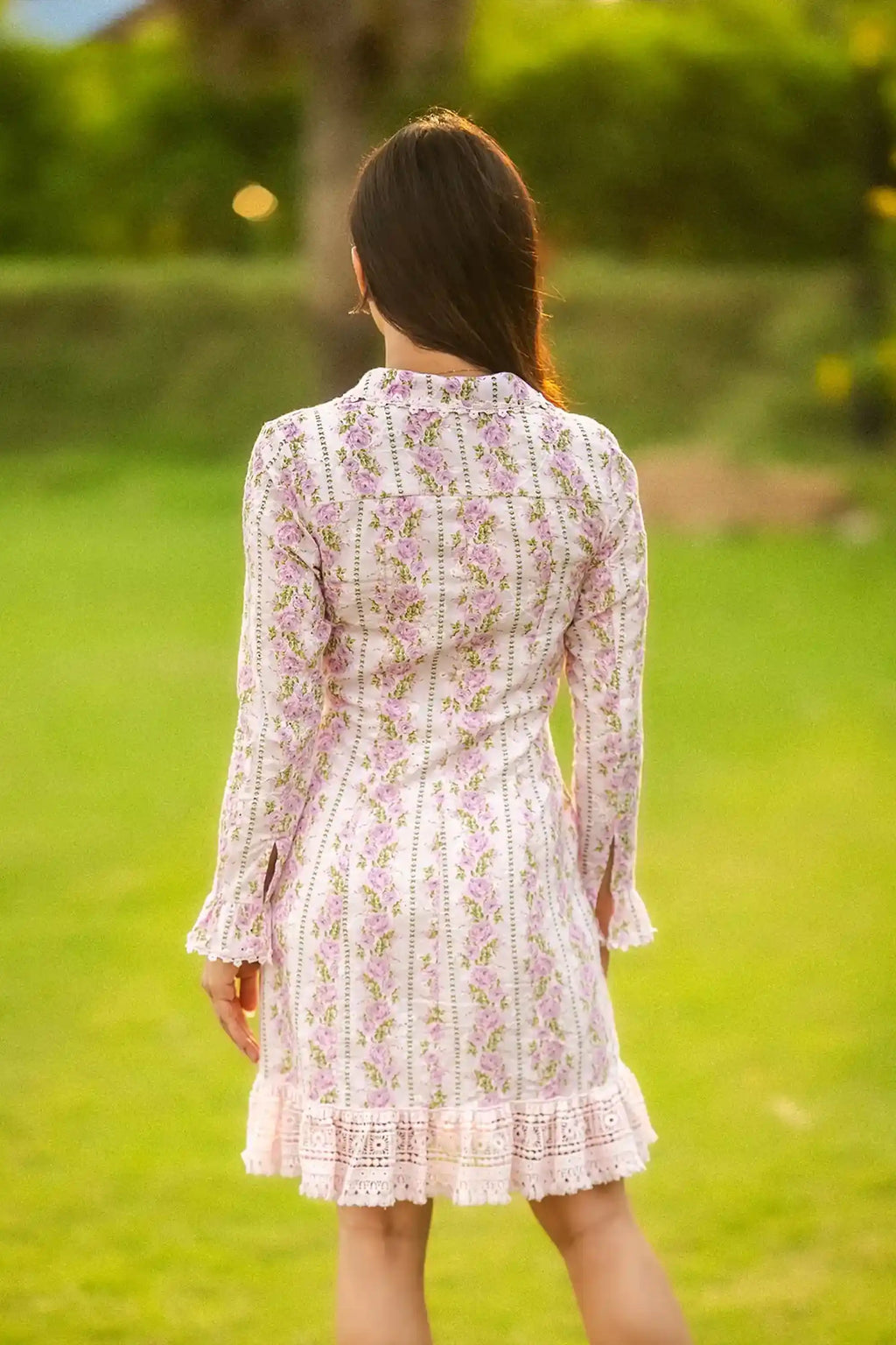 Back view of white floral mini dress with pink rose print