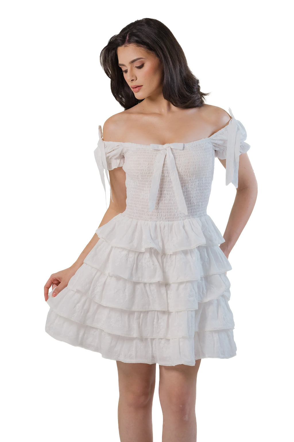 White smocked tiered mini dress with bow straps, front close-up