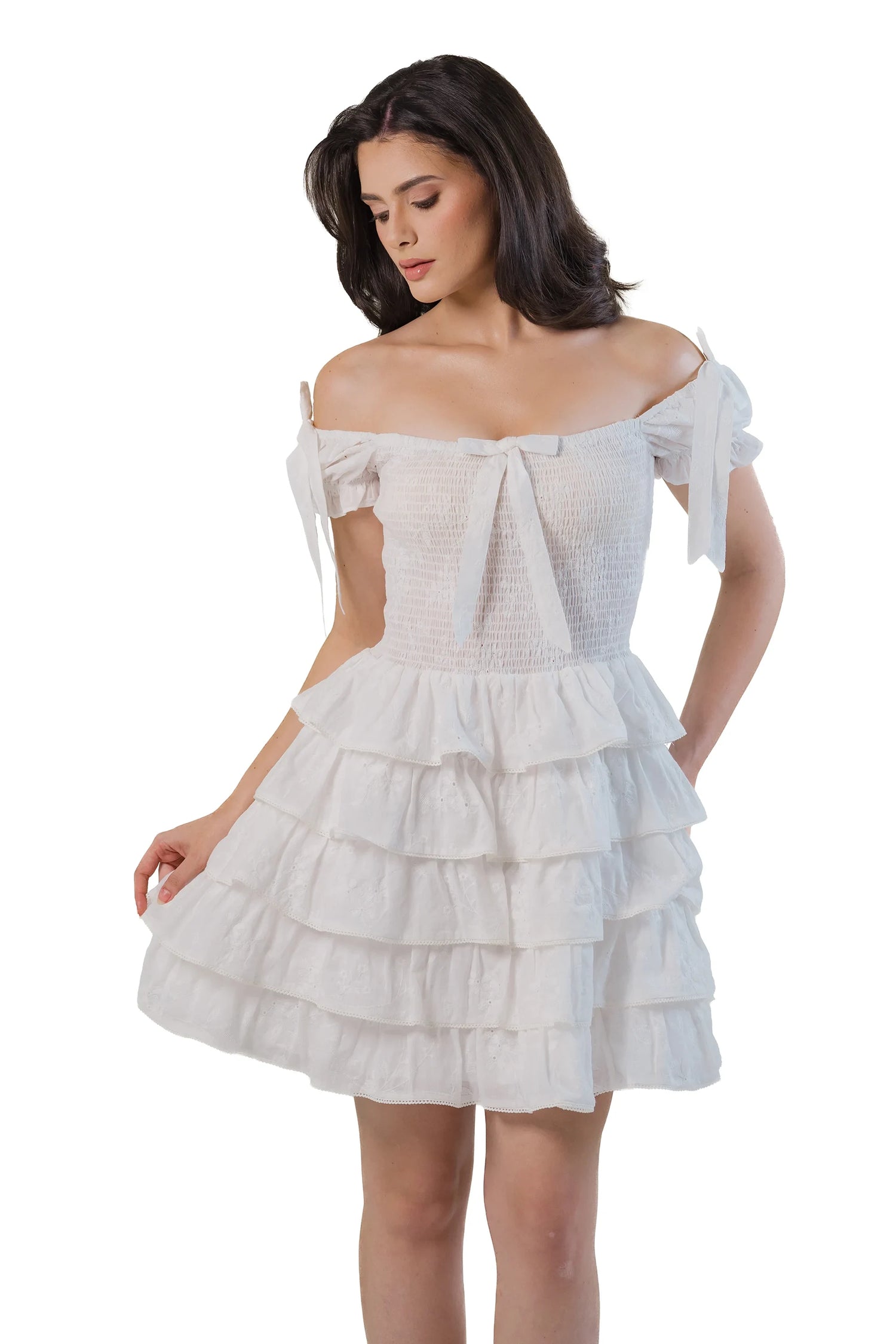 White smocked tiered mini dress with bow straps, front close-up