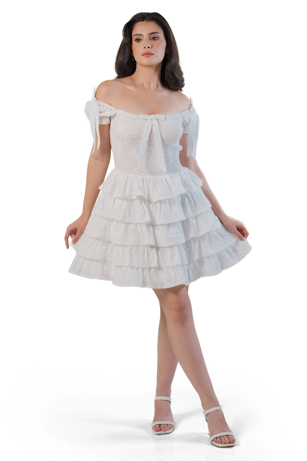 Front view of white smocked tiered mini dress on model