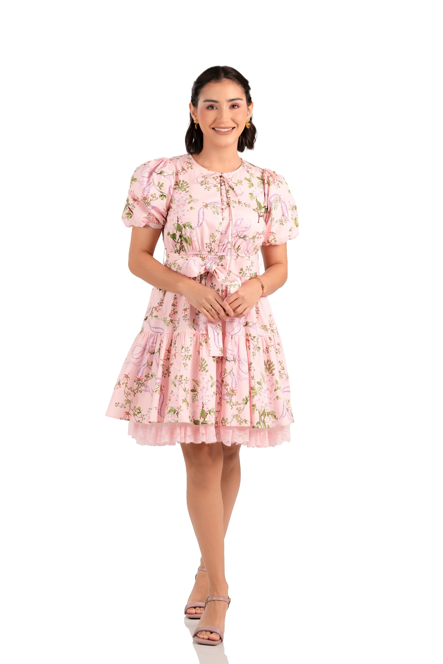 Front view of pink floral mini dress with puff sleeves, bow waist and lace hem