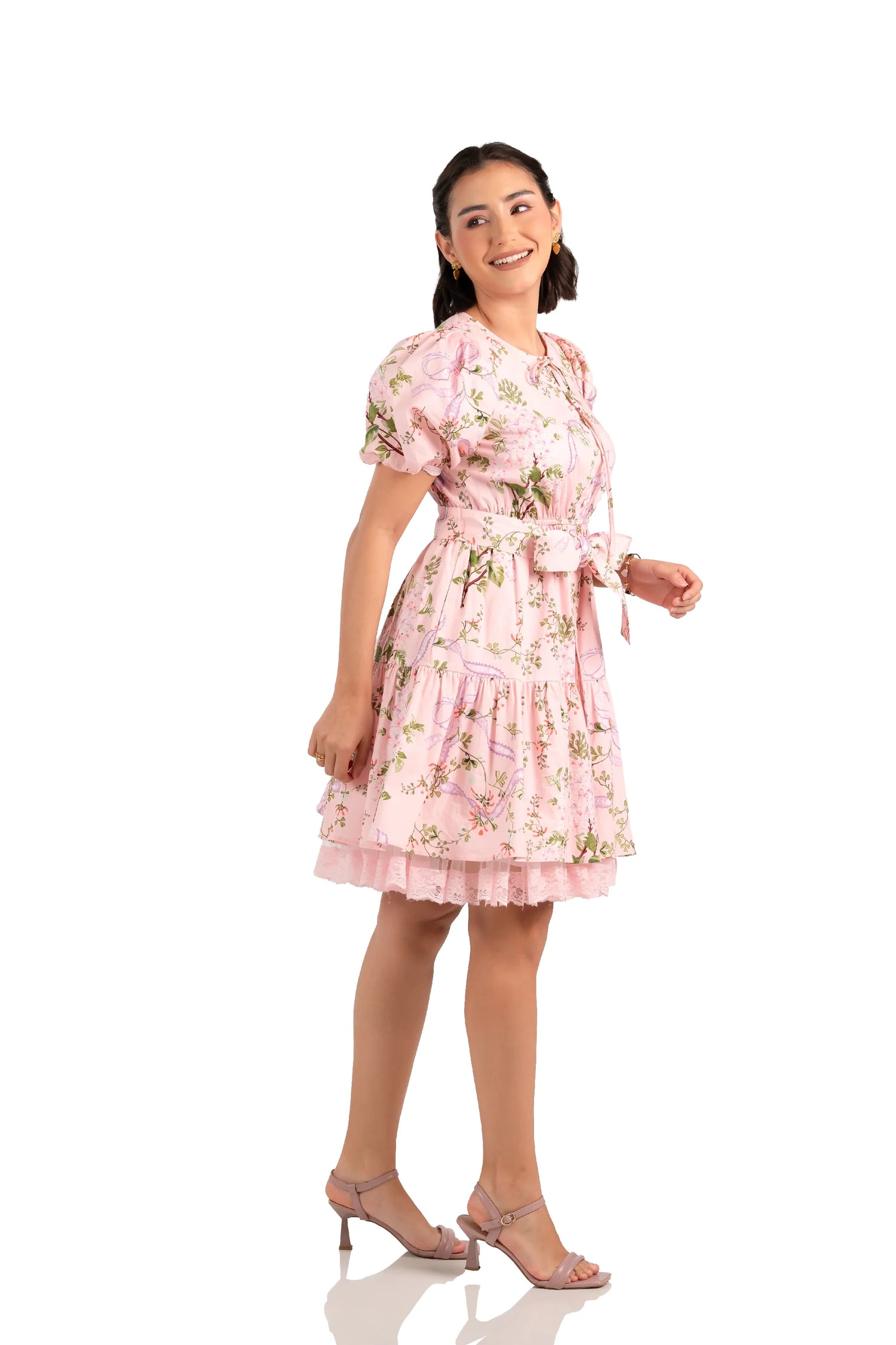 Side view of pink floral bow mini dress with tiered skirt and lace hem