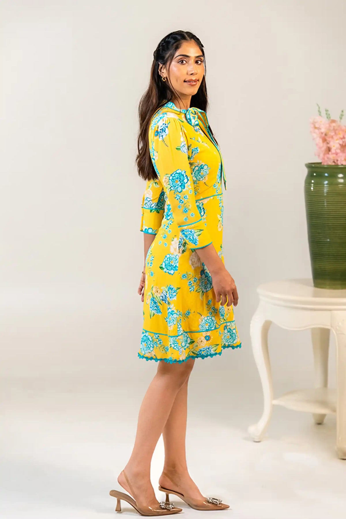 Side profile of yellow floral bow tie short dress
