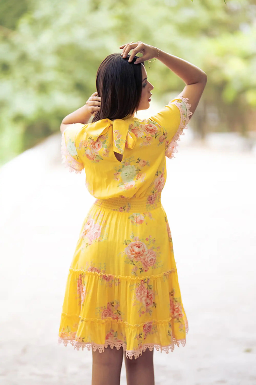 Back view of yellow floral short dress with bow tie