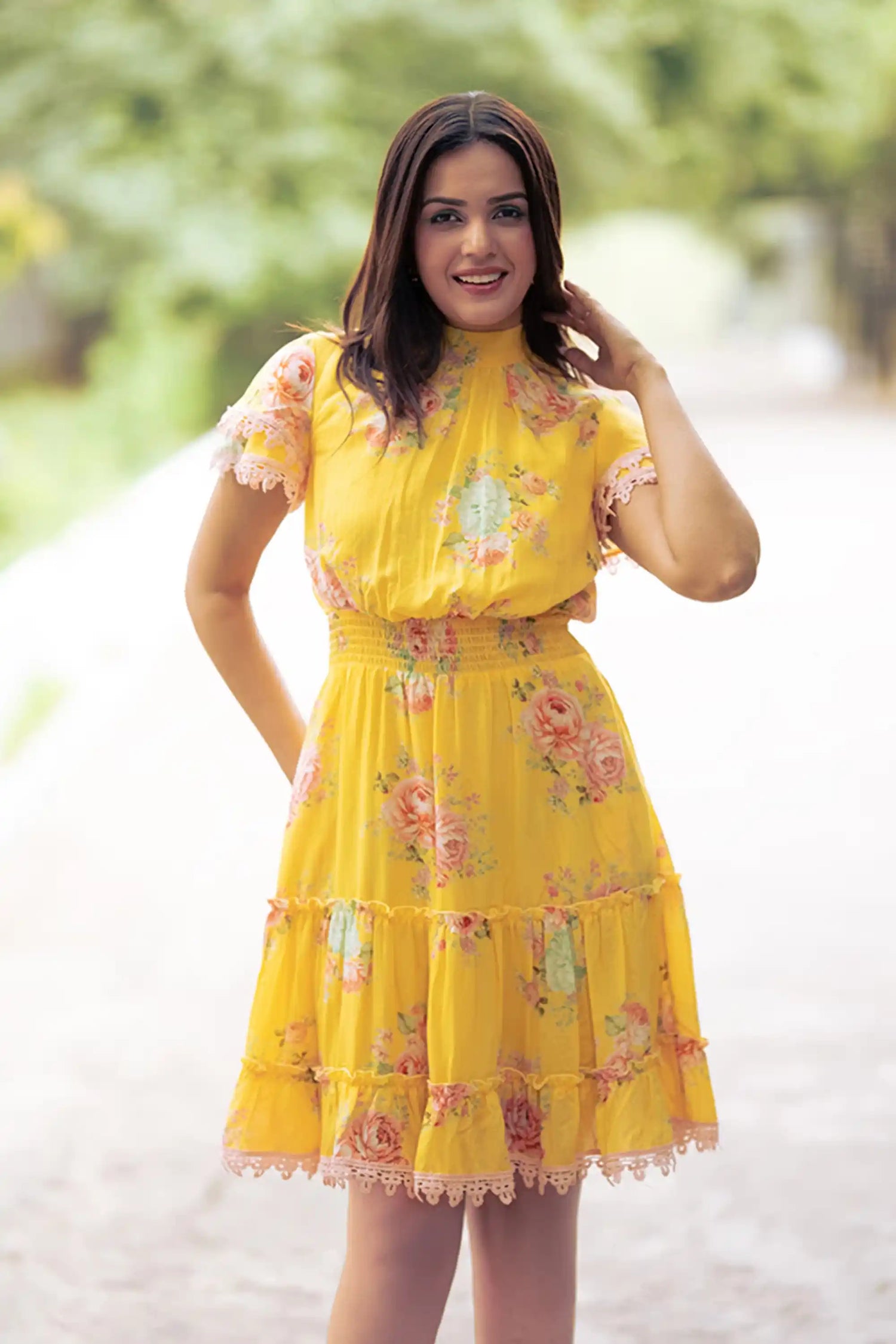 Smiling woman in yellow floral short dress front view