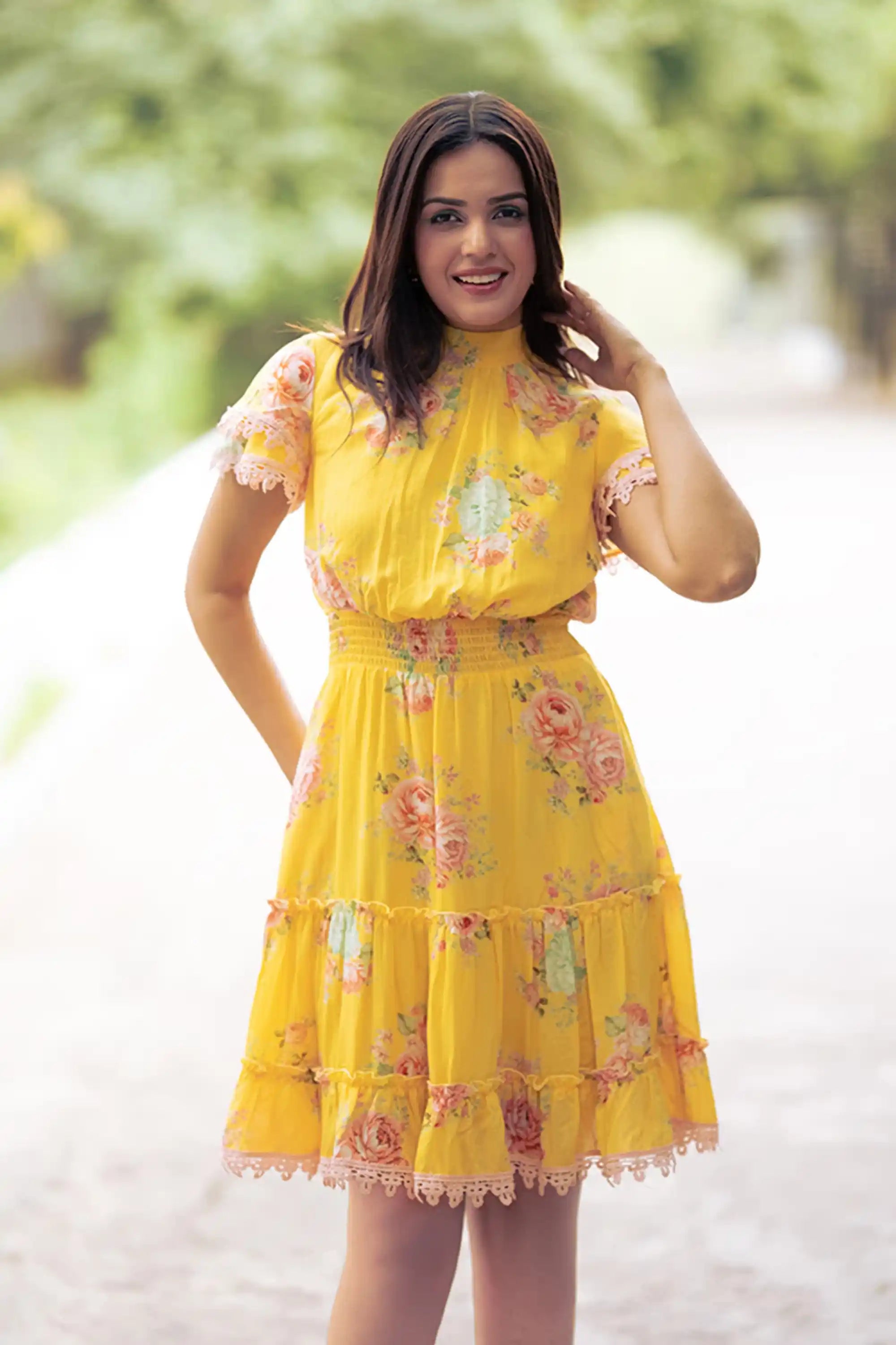 Smiling woman in yellow floral short dress front view