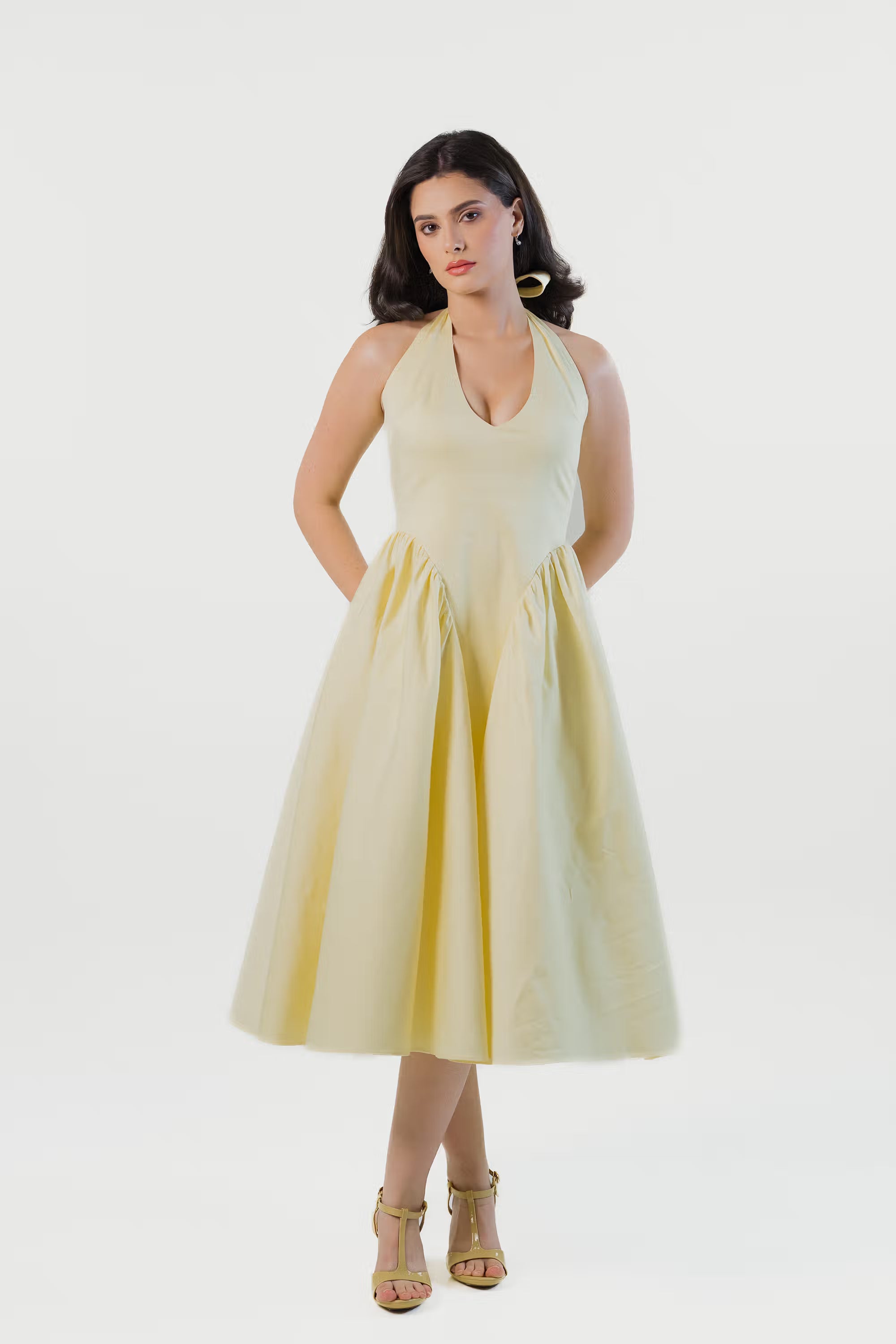 Elegant yellow halter neck midi dress front view with flared skirt and pockets