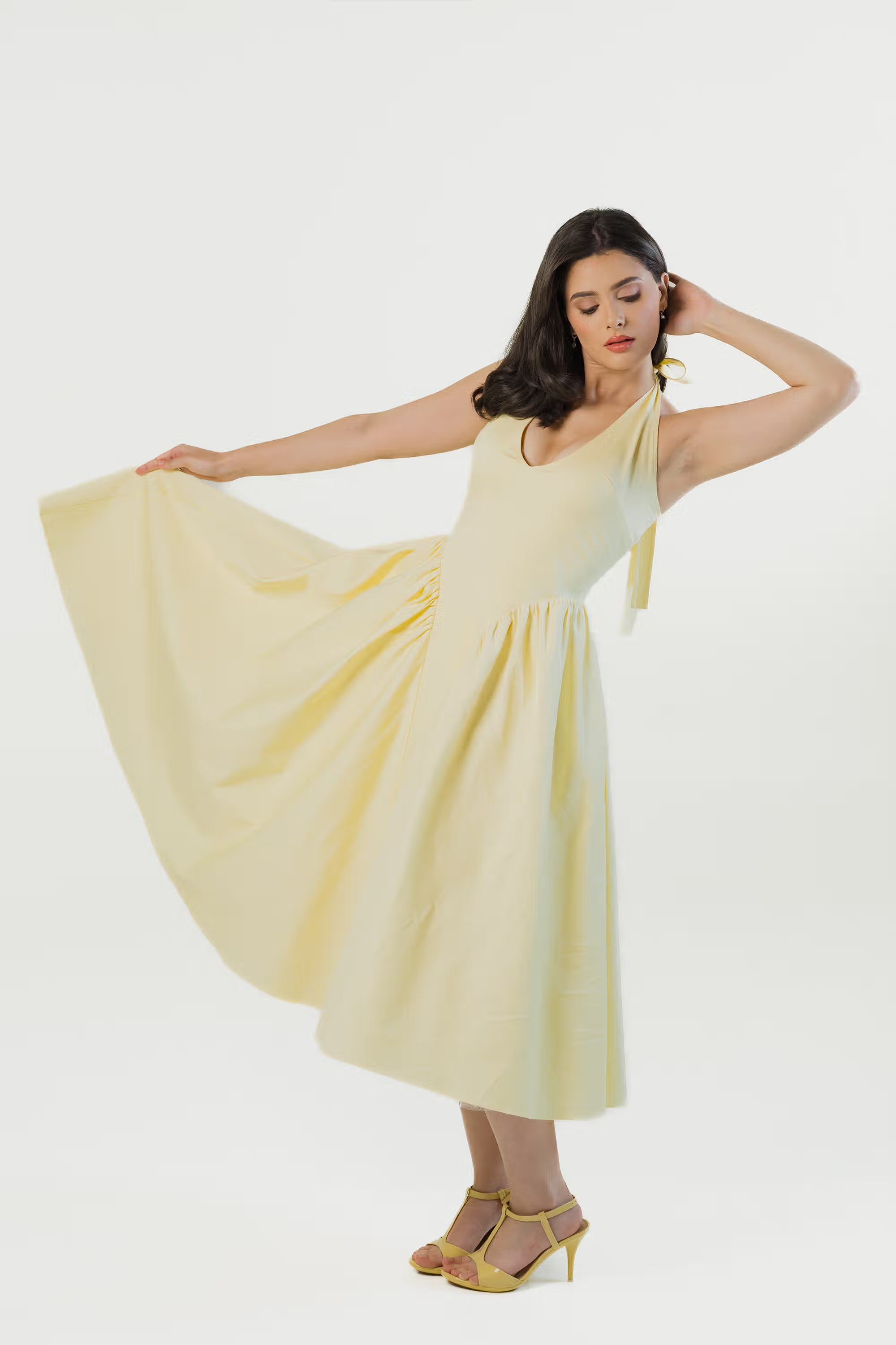 Yellow halter neck midi dress with wide flowing skirt in motion